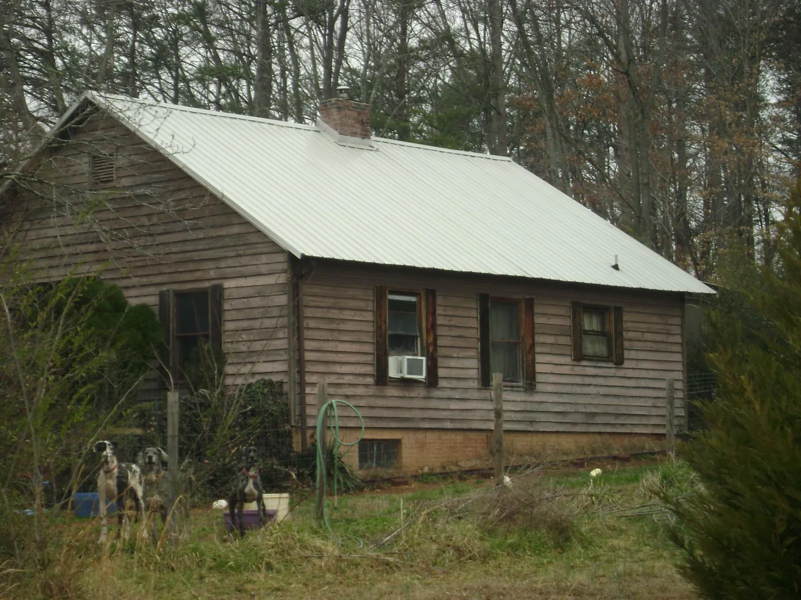 White metal roof on an old wood sided farmhouse, from a Metal Roof Installation job in Stockdale